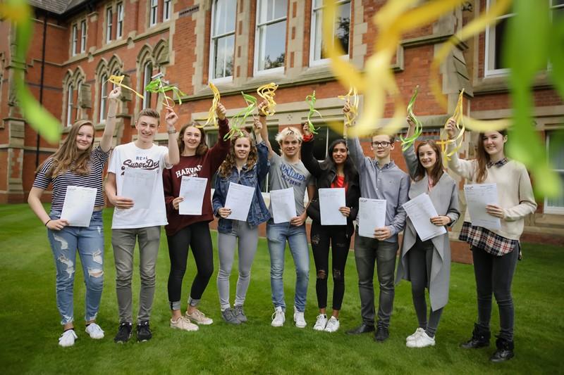 year 11 Students at cheadle hulme school wave green and yellow ribbons in celebration of their GCSE exam results success 2017