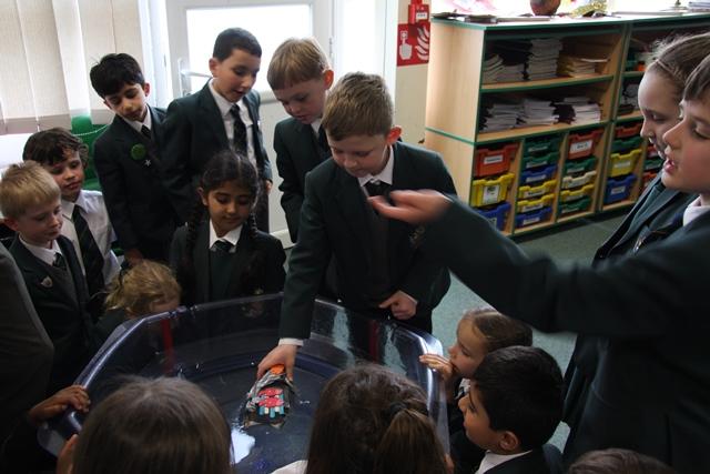 Year 3 students at Cheadle Hulme School Junior School gather round to see if their handmade rafts will sink or swim in their weekly art, science and dt lessons
