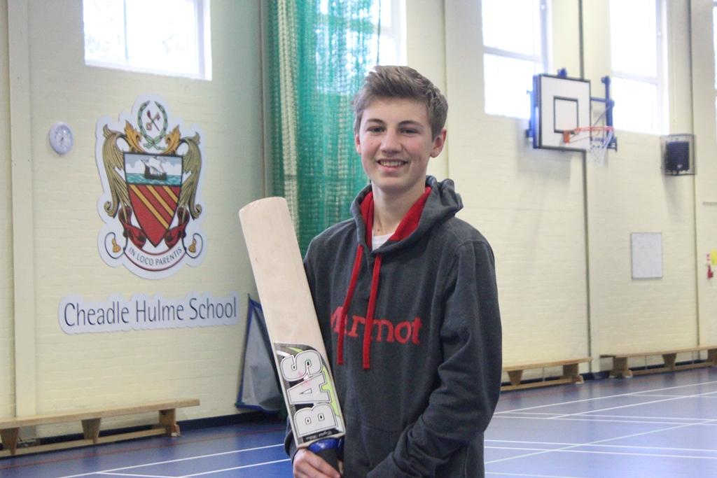 Cheadle hulme school student ben holds a cricket bat in the school gym where he trains after being selected for Cheshire Cricket's Emerging Players Programme
