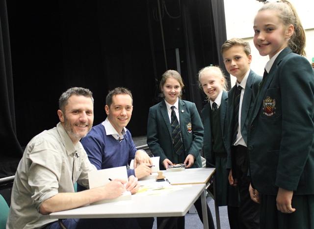 authors nick ostler and mark huckerby sign copies of Defender of the Realm for students at cheadle hulme school when they paid the school a visit  on world book day for world book week 