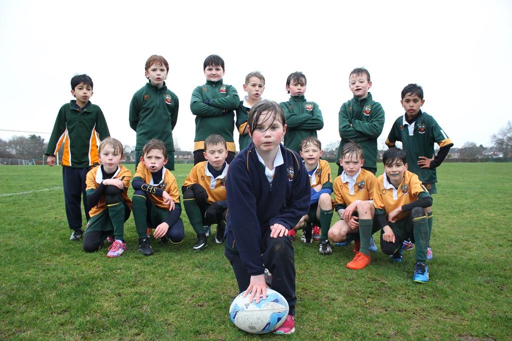 cheadle hulme school junior pupil Molly is captain of the U9s boys team and poses with her fellow players in a squad line up on the fields pitches in the rain