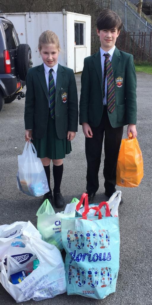 John and Jocelyn drop off the donations cheadle hulme school students hold carrier bags of sanitary donations for their local foodbank chelford which students collected for the charity