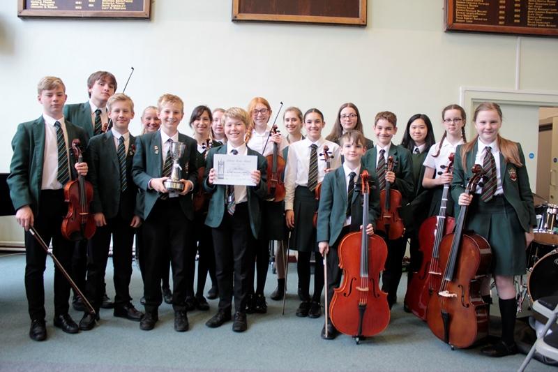First Prize for CHS's Orchestra music students in cheadle hulme school's orchestra hold string instruments including violins violas cellos and double bass and their trophy cup after winning first prize in the Adderley edge music festival competition