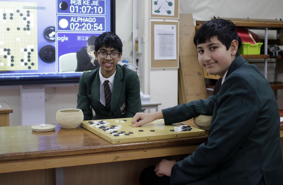 Sam plays fellow CHS Go Club member Rohit Cheadle Hulme School Go players with Go board in science classroom
