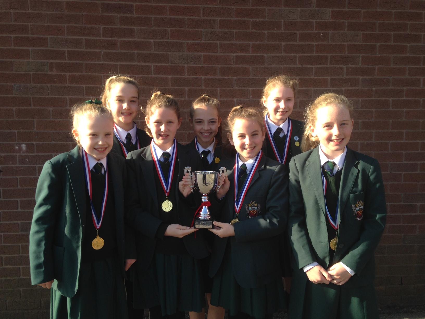 cheadle hulme school's year 6 netball girls hold their trophy after winning gold in the U11s North West Netball Tournament